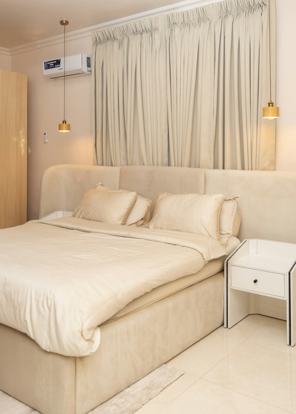 Bed made up with neutral bedding and pillows
